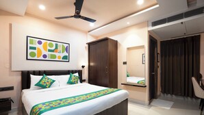 Camera d'albergo moderna con un letto grande, un armadio, una ventola a soffitto e un bagno con uno specchio e delle tende.
