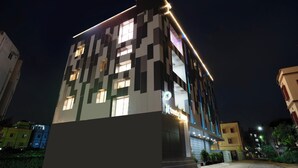 Un edificio moderno con finestre illuminate e un cartello 'treo' ben visibile, che suggerisce uno spazio commerciale.