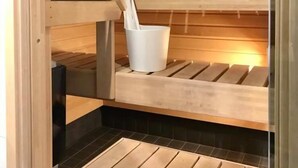 En bastu med träbänkar och en vit hink.