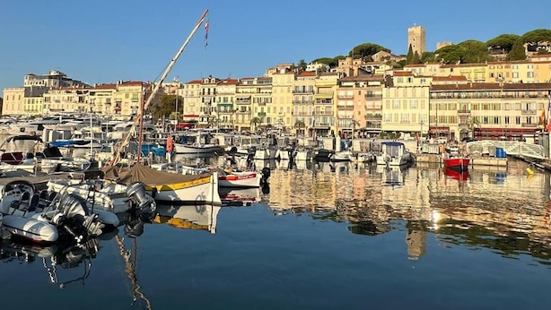 A marina with boats docked, a crane, and buildings in the background. - Nice Living Cannes Plage (Cannes)