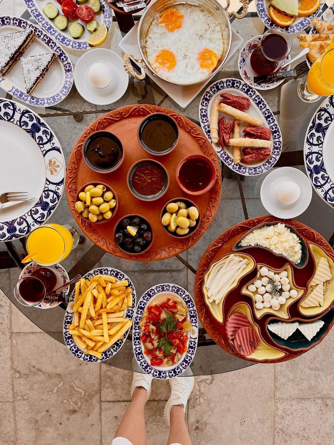 A table set with various dishes including eggs, bread, olives, and cheese.