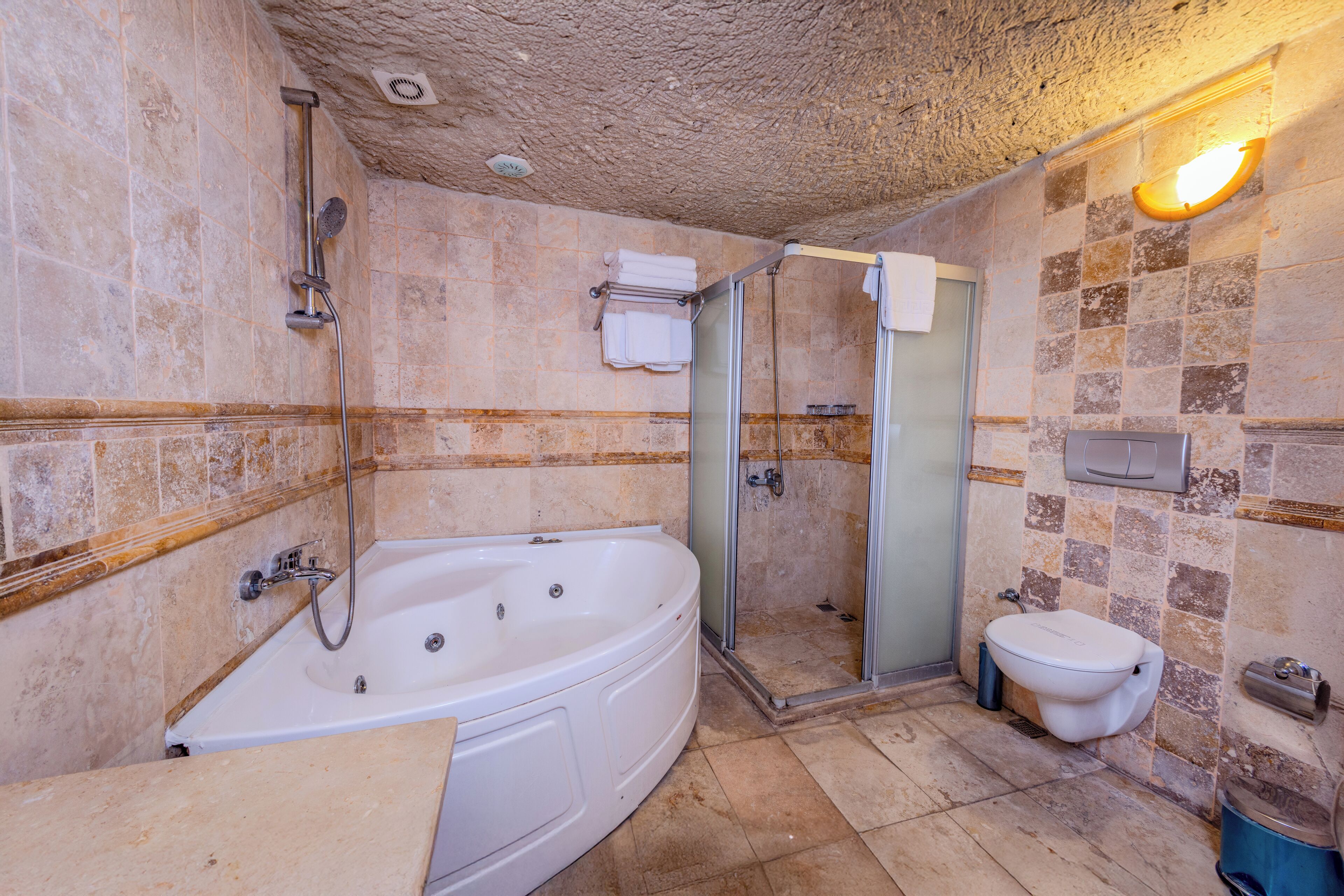 A bathroom with a bathtub, toilet, and shower area.