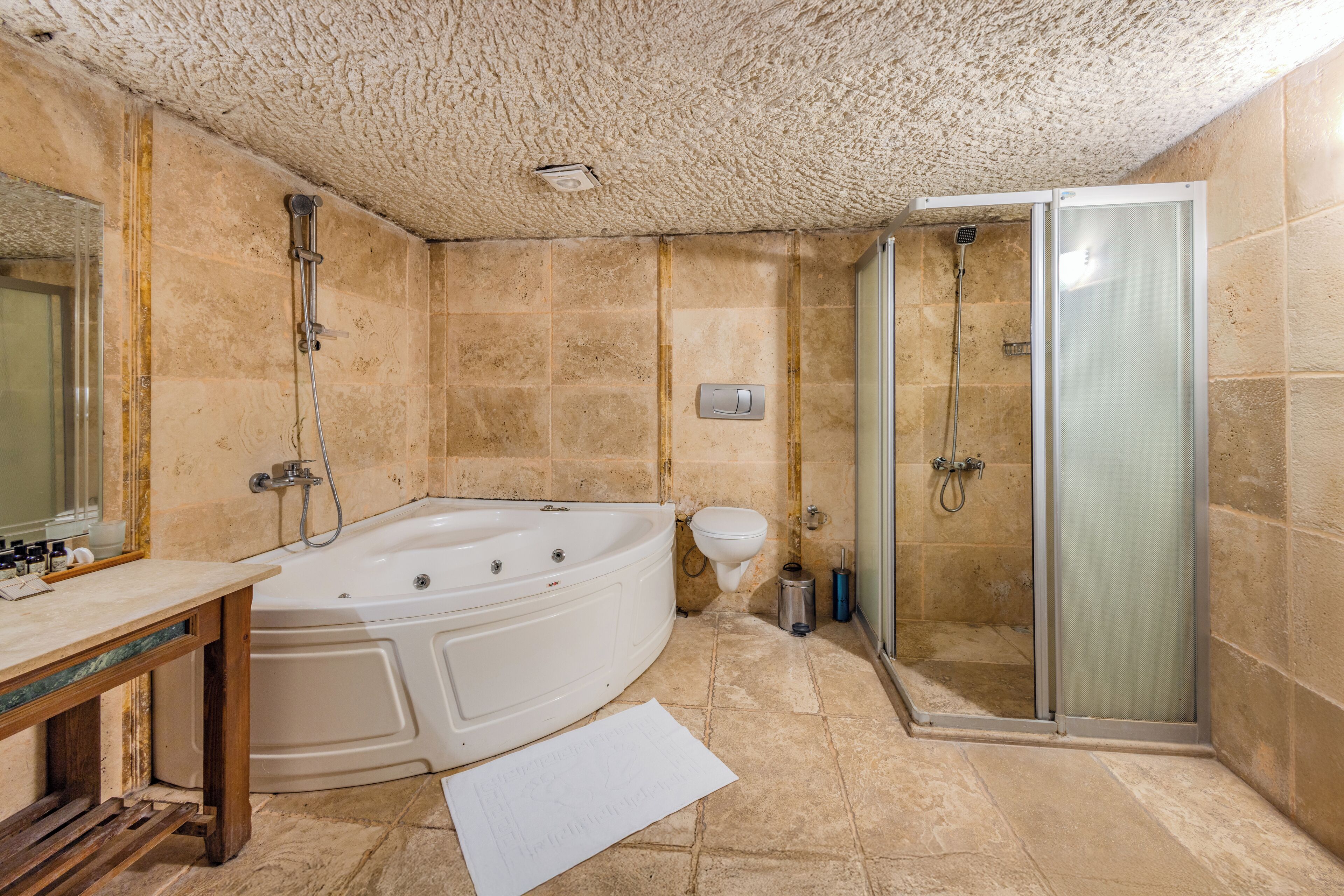 A bathroom with a bathtub, a toilet, and a shower area.