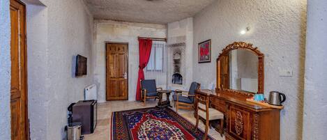 A room with a wooden cabinet, a large mirror, and a patterned rug.