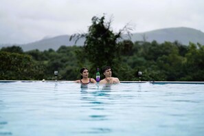 Una piscina al aire libre, sillones reclinables de piscina
