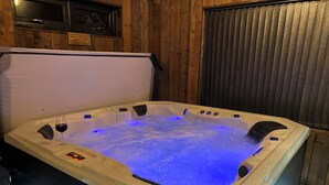 A hot tub with a control panel and a glass of red wine. - Wayside Lodge (Blackpool)