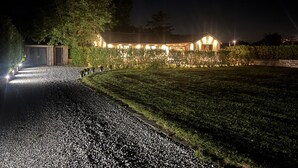 A well-lit building with a gravel driveway leading to a wooden structure. - Wayside Lodge (Blackpool)