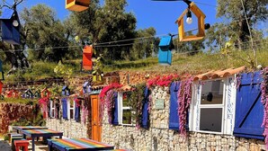 Terraza al aire libre con muros de piedra y bancos de colores.