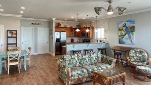 A spacious living area with a sofa, chairs, and a dining table. - Beachgate Condo Suites And Hotel 341+342 4 Bedroom Condo (Port Aransas)