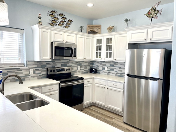 Enjoy cooking in this well-equipped kitchen with a double oven, microwave, and large sink.