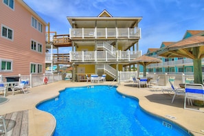 Relax by the pool surrounded by lounge chairs and umbrellas, with stunning views from the hotel's balconies.