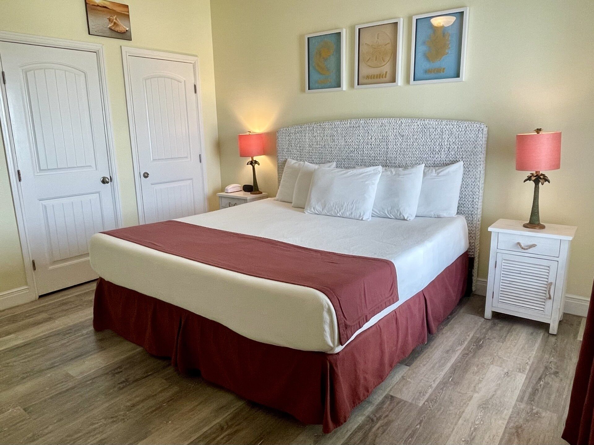 A neatly arranged bedroom with a large bed, two bedside tables, and a door.