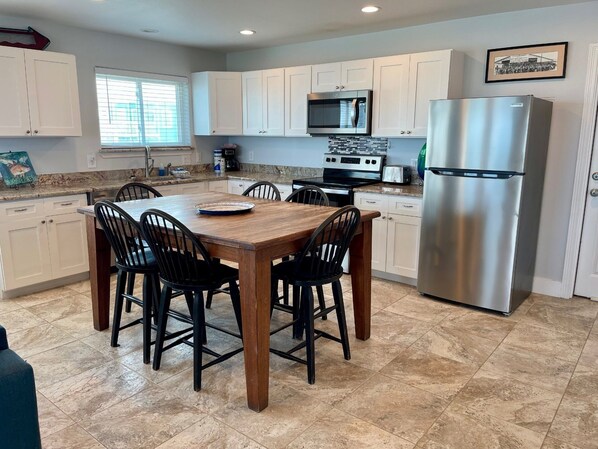 A modern kitchen with white cabinets, a stainless steel refrigerator, a microwave, and a stove. - Beachgate Condo Suites And Hotel 237+238+239 3 Bedroom Condo (Port Aransas)
