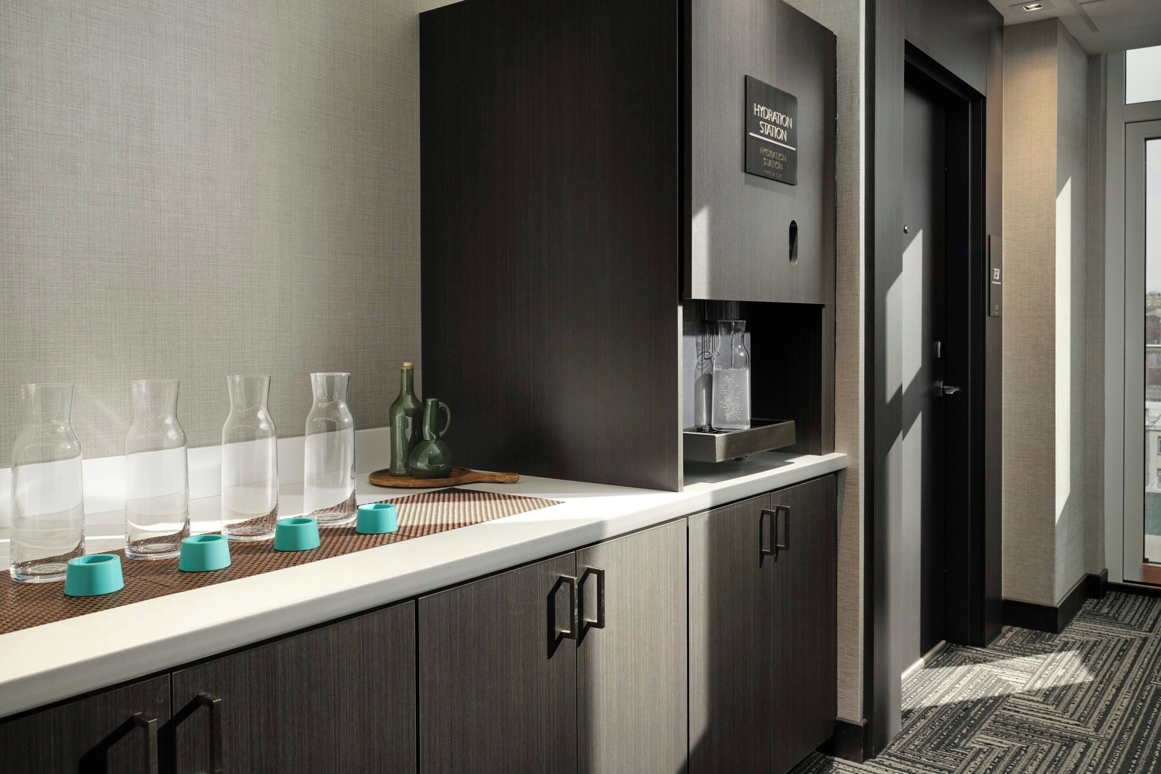 A modern kitchen with a built-in coffee machine, a water dispenser, and a microwave.