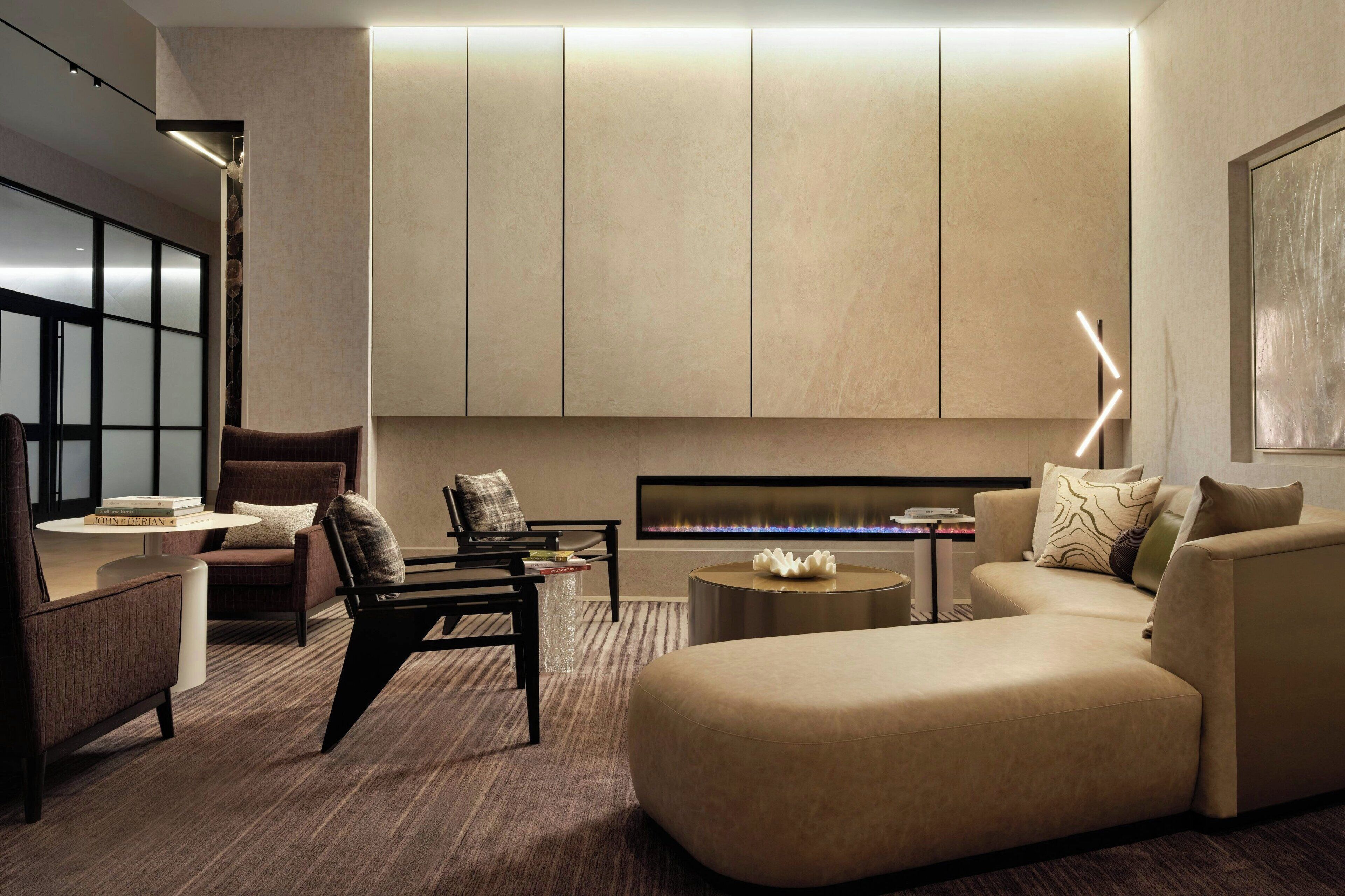 A modern living room with a sectional sofa, a coffee table, and a fireplace.