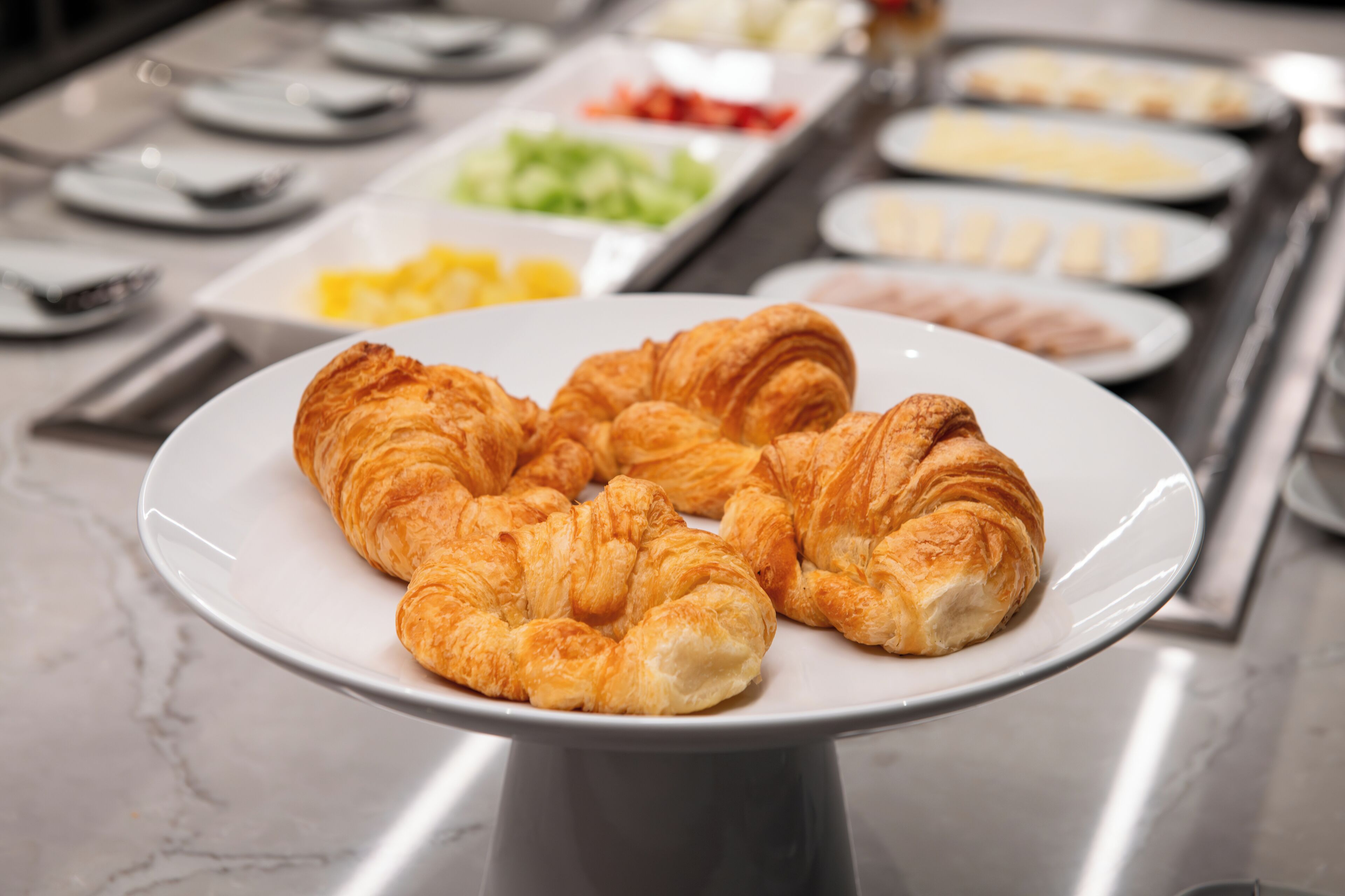 Un buffet de petit-déjeuner avec des croissants sur une assiette.