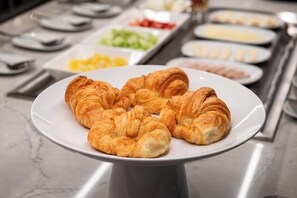 A breakfast buffet with croissants on a plate. - AC Hotel Burlington (Burlington)