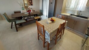 A dining area with a wooden table and chairs, a bench, a mirror, and a refrigerator. - Rethymno Suburb Maisonette (Rethymno)