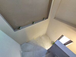 A staircase with a landing area featuring a small shelf with decorative items. - Rethymno Suburb Maisonette (Rethymno)