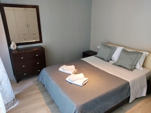 A neatly arranged bedroom with a bed, a dresser, and a nightstand. - Rethymno Suburb Maisonette (Rethymno)
