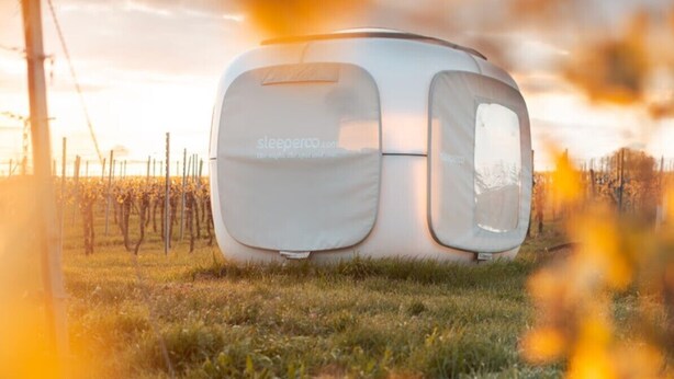 A modern, white, cube-shaped structure in a vineyard with a clear sky. - Romantik zwischen Weinreben - Cube (Roemerberg)