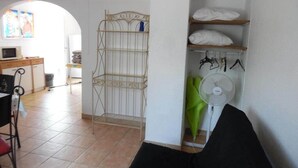 A room with a bed, a chair, a desk with a computer, a fan, and a shelf with clothes. - 8 pers, 200m from the sea, garden, ground floor, closed private parking, independent entrance (Marseillan)