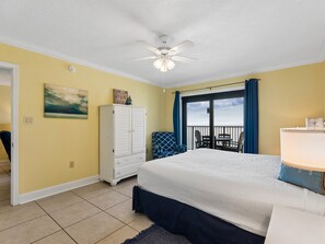 A bedroom with a bed, a white wardrobe, a painting, and a balcony with a view.