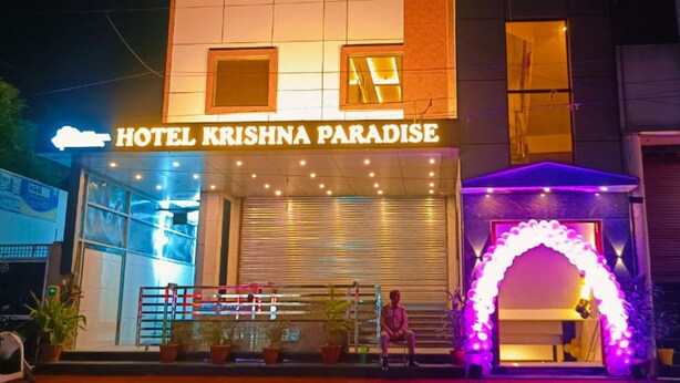 The exterior of Hotel Krishna Paradise with a prominent entrance, a seating area with potted plants, and a decorative archway. - HOTEL KRISHNA PARADISE (Agra)