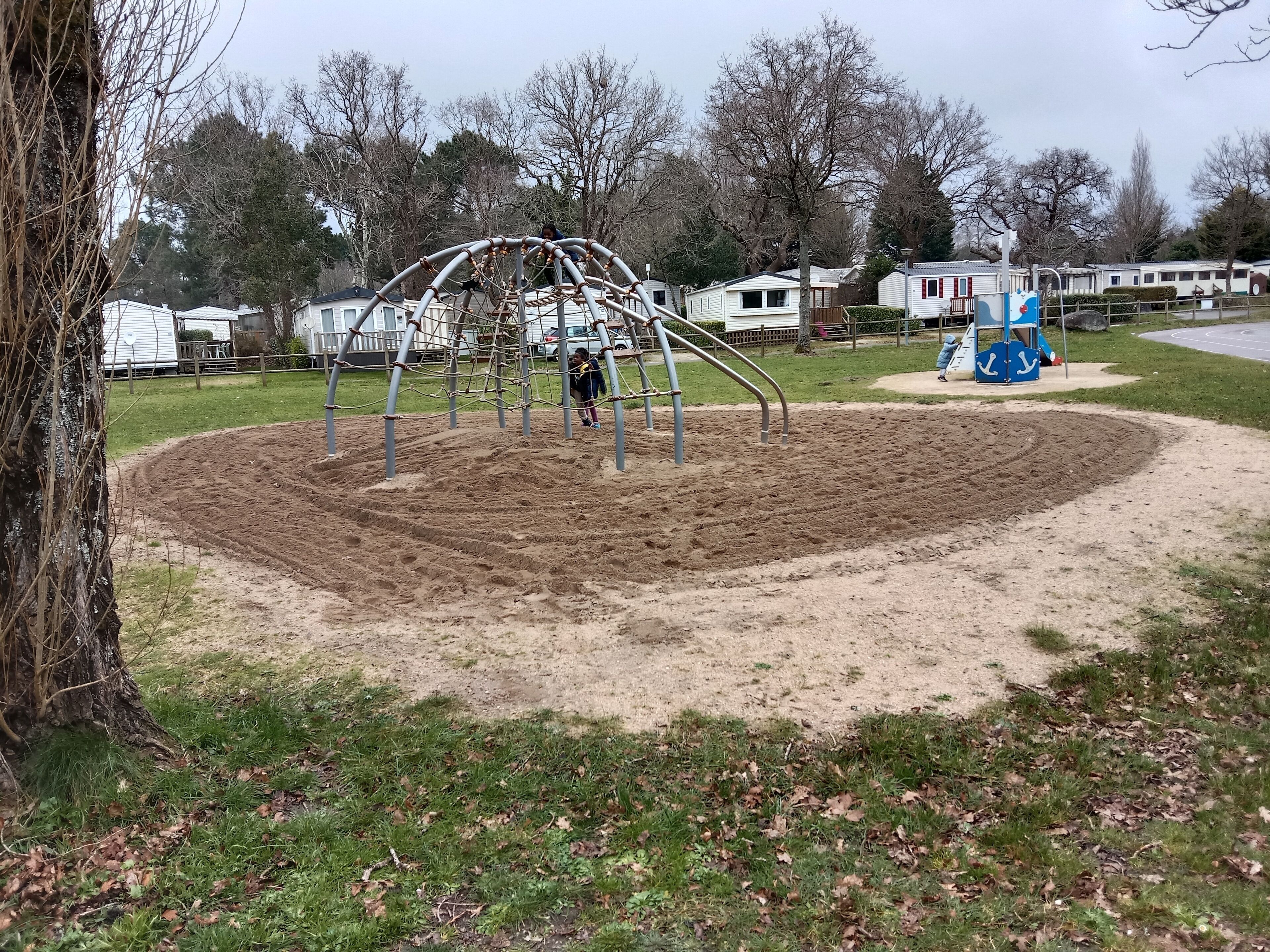 Ein Spielplatz mit Schaukel und Sandkasten.