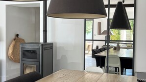 Een moderne eetruimte met een houten tafel, zwarte stoelen en hanglampen.