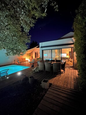 A modern outdoor deck with a pool, seating area, and a glass-enclosed room. - Luxury Villa for Rent in Balaruc-les-Bains (Balaruc-les-Bains)