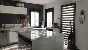 Een moderne keuken met een centraal eiland, witte kastjes en een vloer met een patroon.
