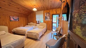 Una habitación de cabaña de madera con dos camas, una silla y una ventana.