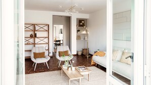 A modern living room with a sofa, armchairs, a coffee table, and a bookshelf. - Moonlight (San Fermo della Battaglia)