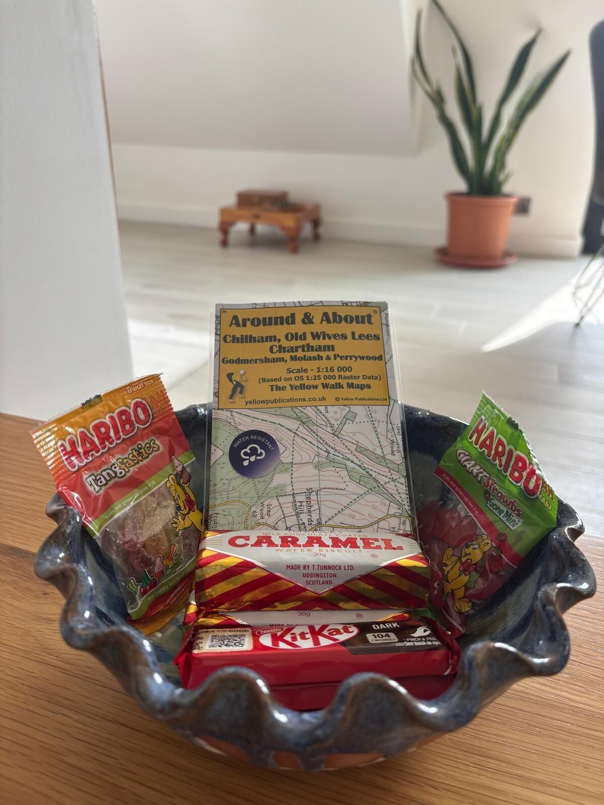 A tray with a map, Haribo gummy bears, KitKat chocolate bars, and a caramel wafer biscuit.