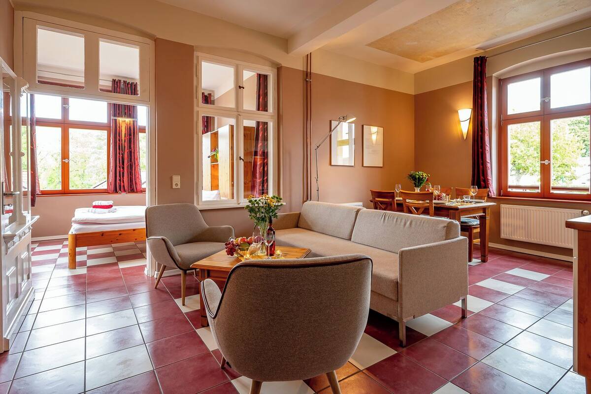 Una sala acogedora con sofá, sillas, una mesa de comedor y una zona de cocina.