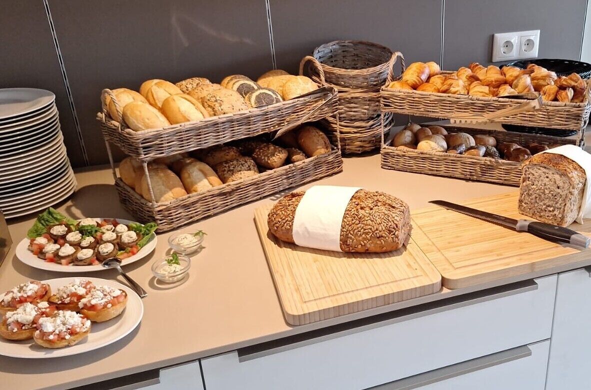Una encimera de cocina con panes y pasteles varios, una tabla de cortar y un cuchillo.