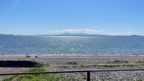 A pebbled beach with a clear view of the sea and distant mountains. - Cliff Top - Bubbling Springs - spectacular sea views. Sleeps 4 guests (Wemyss Bay)