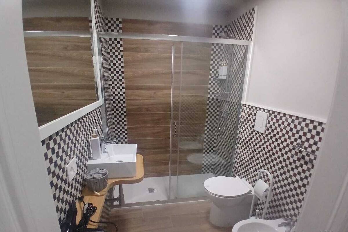 A compact bathroom with a shower, toilet, and sink.