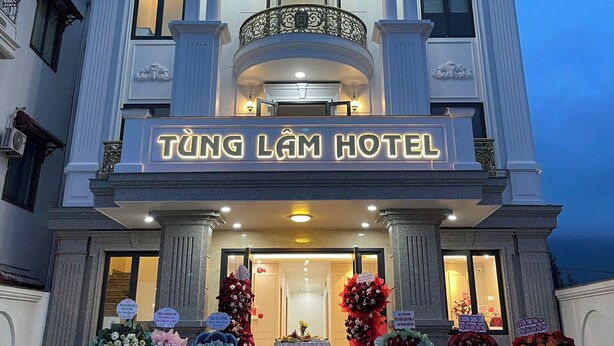 Fachada imponente de un hotel, con un balcón y decoración floral.