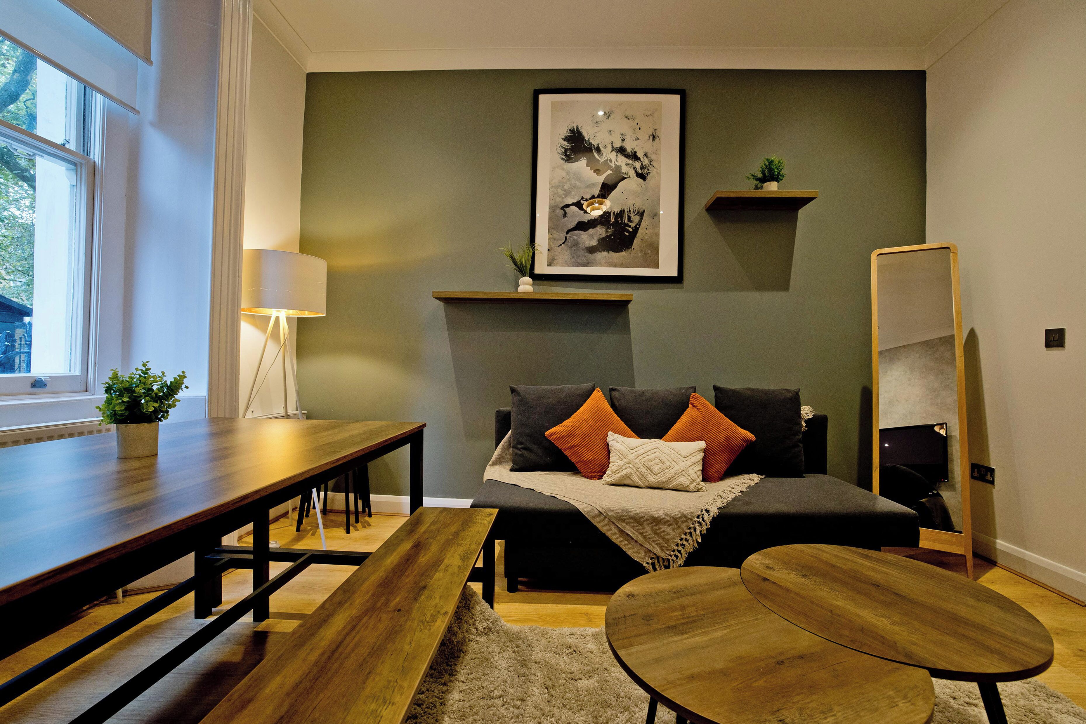 Un salon moderne avec un canapé, une table basse, une lampe et un tableau au mur.