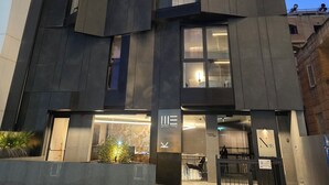 Un hotel moderno con un diseño angular distintivo, que cuenta con varios balcones y amplias ventanas.