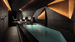 A modern indoor pool area with geometric walls, a long pool, and lounge chairs. - Thirty Three Boutique -Adults Only By K Hotels (St. Julian's)