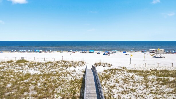 A beach with a wooden boardwalk leading to the sand, tents, and beach umbrellas. - NEW LISTING!!! Gulfside Villa 2B-  AMAZING beachfront view  NO HASSLE CHECK OUT (Perdido Key)