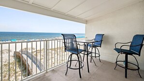 A balcony with a view of the beach, a table, and two chairs. - NEW LISTING!!! Gulfside Villa 2B-  AMAZING beachfront view  NO HASSLE CHECK OUT (Perdido Key)
