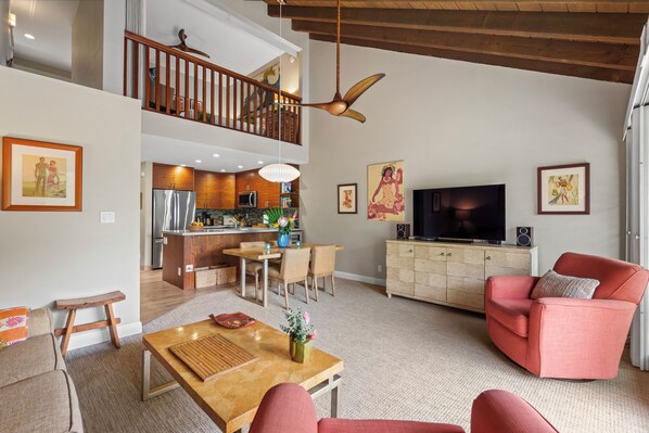 Ein geräumiges Wohnzimmer mit Holzboden, einer Essecke, einer Küche und einem Balkon.