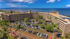 Ein Hotel mit Parkplatz, mehreren Etagen und Meerblick.