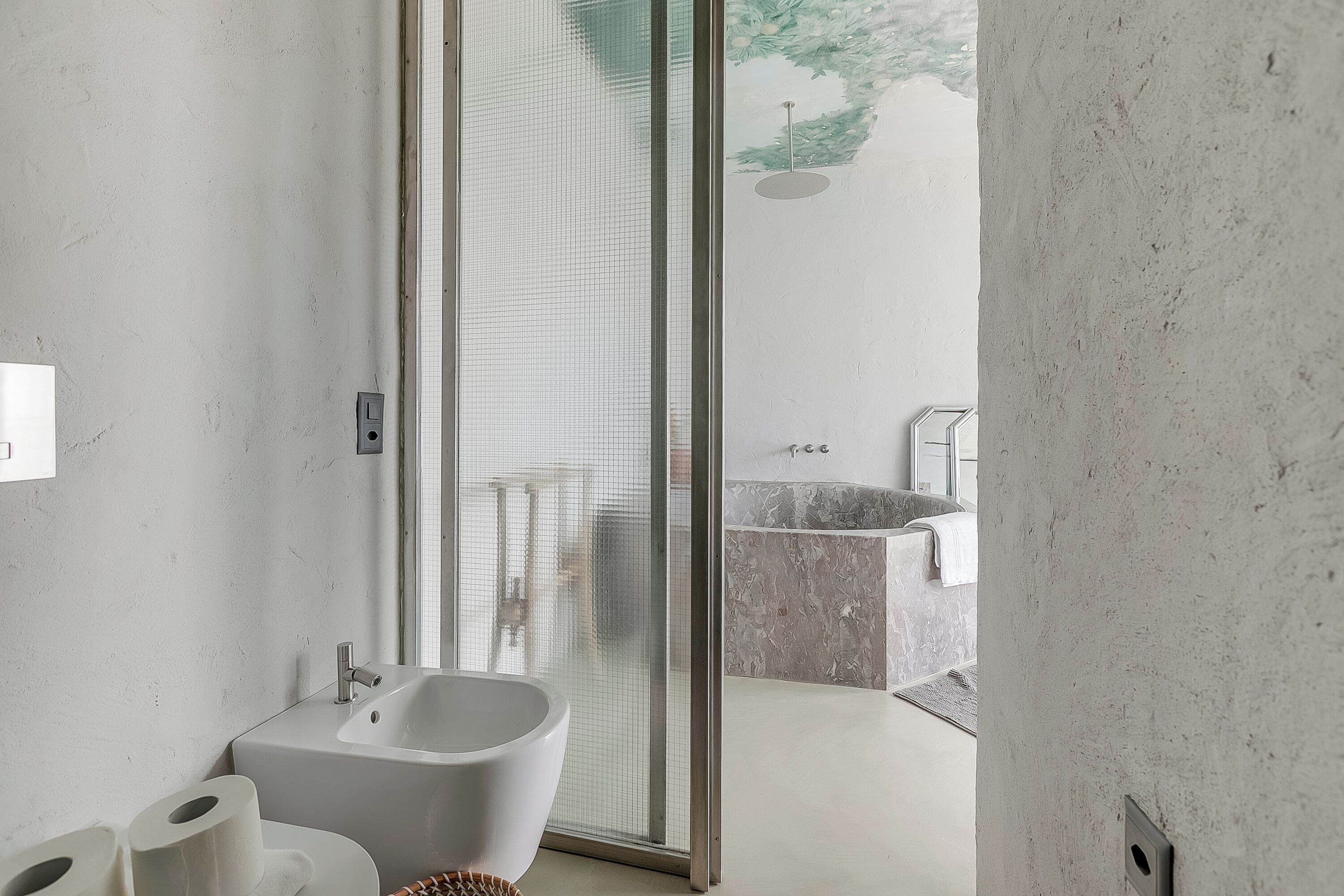 A modern bathroom with a bathtub, toilet, and shower area.