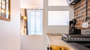 Eine moderne Küche mit Backsteinwand, Holzarbeitsplatte und integriertem Ofen.