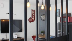 Ein moderner Büroraum mit großem Flachbildfernseher, einer Uhr und einem Hinweisschild für den Ausgang.
